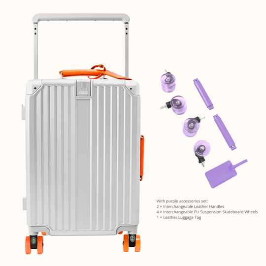 A silver aluminum hard-shell suitcase with orange accents and a telescoping handle, shown alongside purple accessories including two leather handles, four PS suspension skateboard wheels, and a luggage tag on a light beige background.